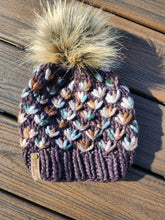 Load image into Gallery viewer, Brown beanie with green and tan multicolor flowers. Topped with a tan lux pom.