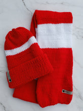 Load image into Gallery viewer, Red and white striped scarf next to a red double brim beanie with a white stripe around it.