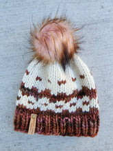 Load image into Gallery viewer, Colorwork beanie in ivory and brown colors with pink tones. Colorwork pattern consists of stripes and spots. Topped with a brown and pink faux fur pom.