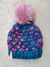 Load image into Gallery viewer, Teal beanie with purple and pink multicolor lotus flower pattern. Topped with large pink faux fur pom.
