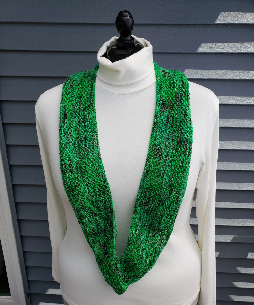 Infinity scarf in bright green yarn with pops of red and sparkles. 