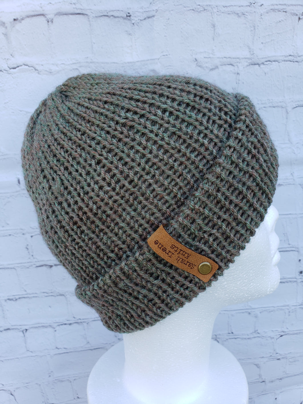 Double brim beanie in light green with speckles of tan and red. No pom.