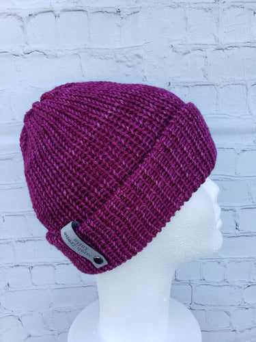 Double brim beanie in a reddish pink color. No pom.