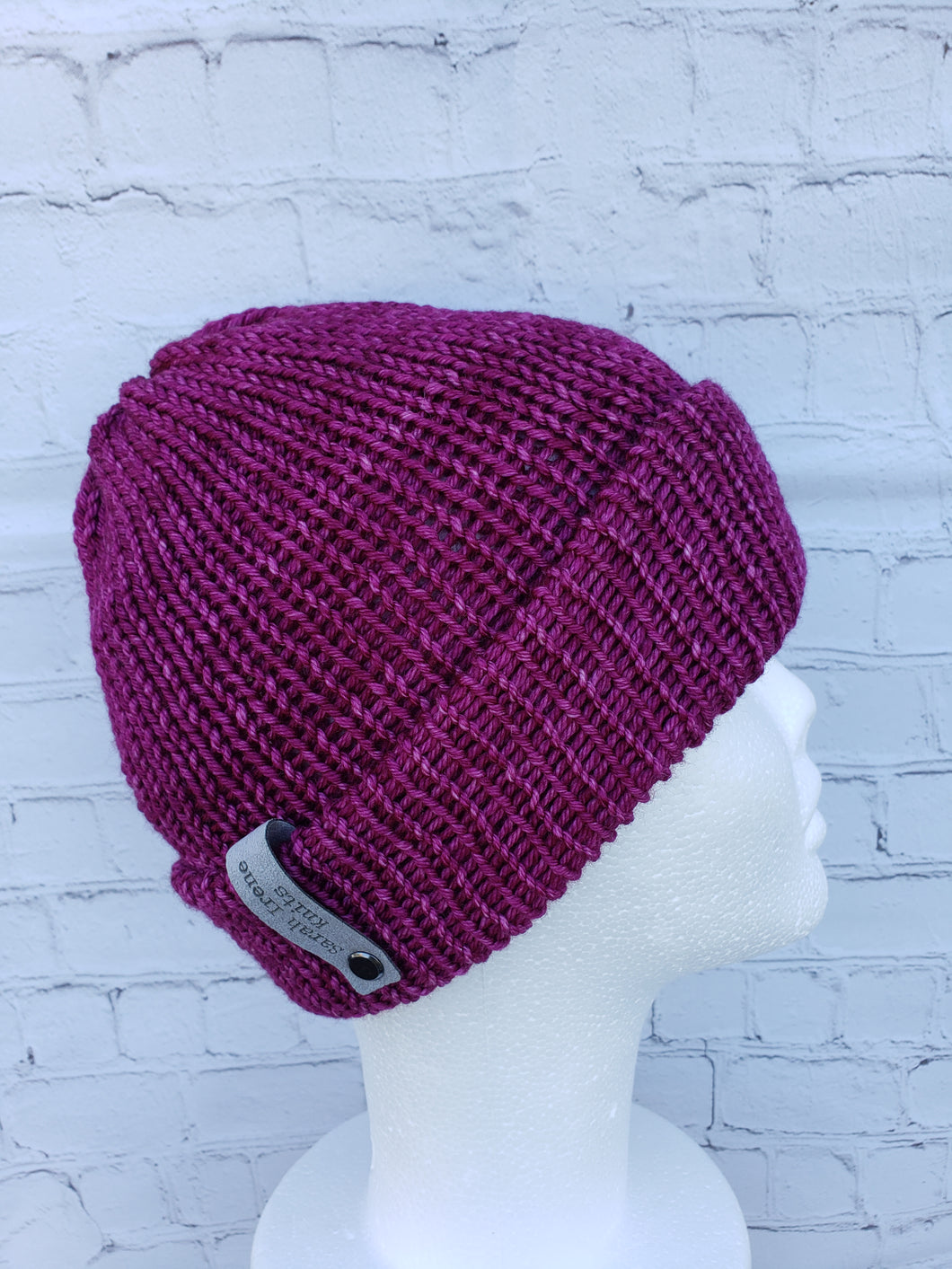 Double brim beanie in a reddish pink color. No pom.
