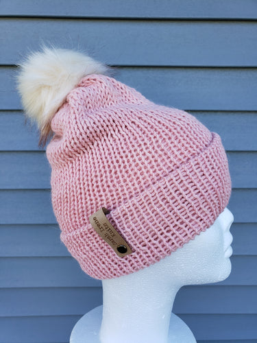 Pink double brim beanie topped with an ivory faux fur pom.