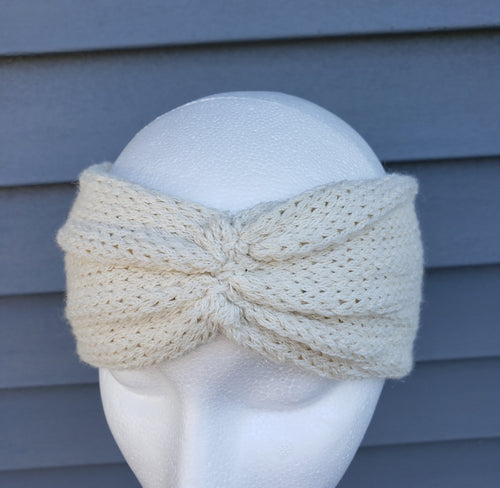 Ivory headband with cinched middle that wraps around ears and forehead.