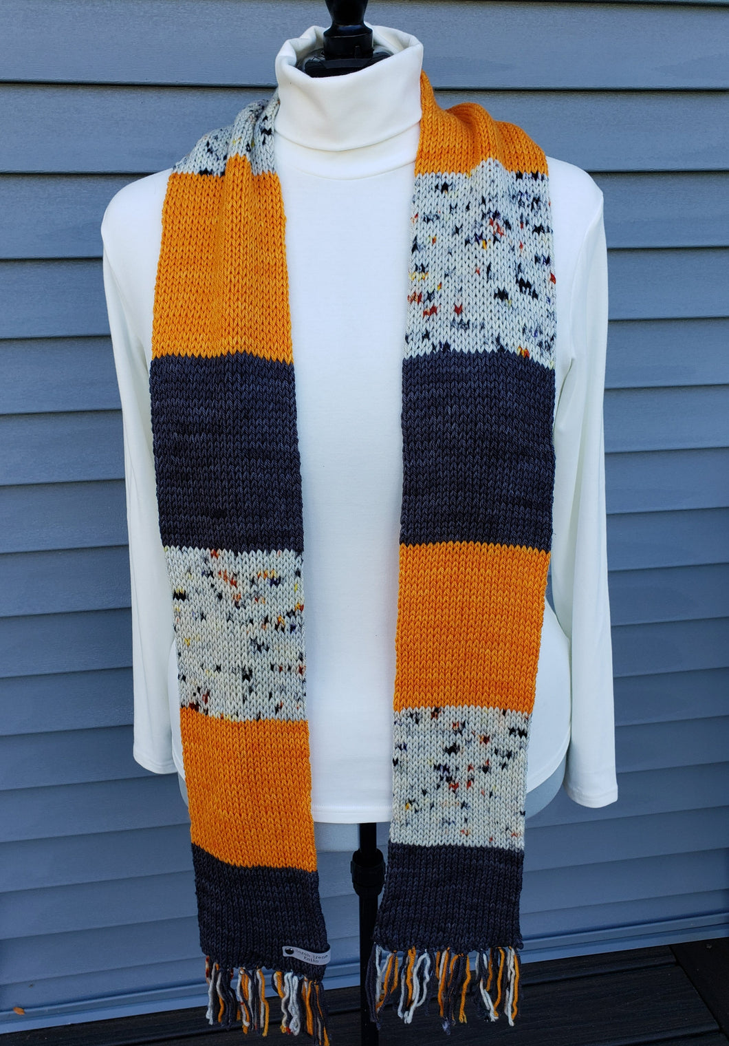Scarf on model with black/grey, orange, and matching grey speckled blocks.