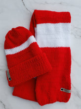 Load image into Gallery viewer, Red and white striped scarf next to a red double brim beanie with a white stripe around it. 
