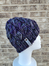 Load image into Gallery viewer, Cable effect beanie in purple, grey, and blue variegated color. No pom.
