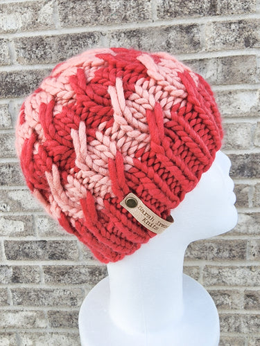 Braided effect beanie featuring red and pink chunky striped rows. No pom.