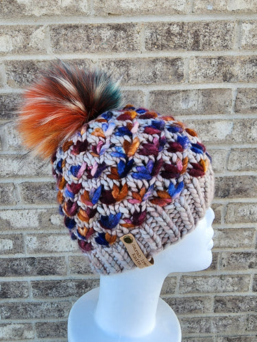 Beige beanie with multicolored lotus flower accents. Topped with multicolor lux faux fur pom.