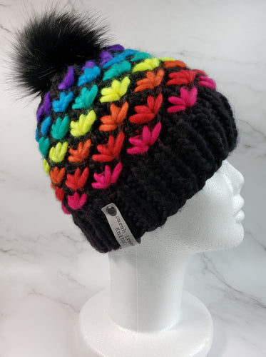 Lotus Flower Beanie in Black with a rainbow of colors for the flowers. A black faux fur pom sits on top.
